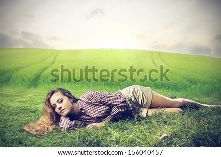 beautiful woman relaxes lying on the grass in the countryside