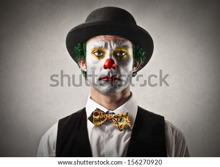 portrait of sad clown with bowler hat and red nose