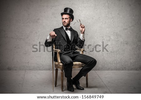 elegant man with cylinder sitting on a chair