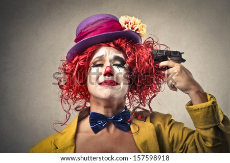 beautiful clown is pointing a gun to her head