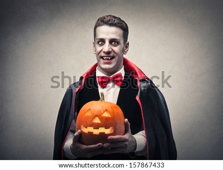 Man Dressed As Dracula With Halloween Pumpkin In Hand