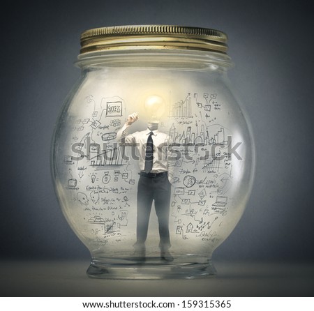 businessman writing with the head in the shape of a light bulb enclosed in a jar