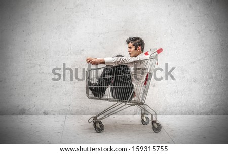 handsome businessman sitting in the shopping cart