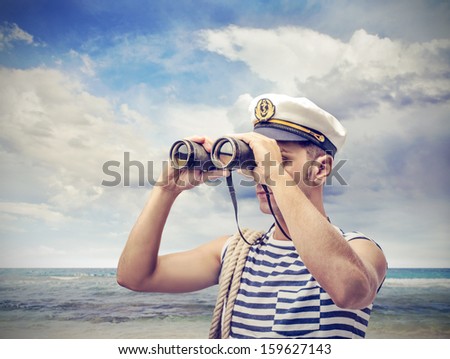 young sailor looks through binoculars