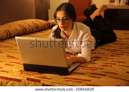 young woman with laptop on the bed