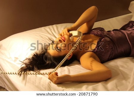young woman at telephone on the bed