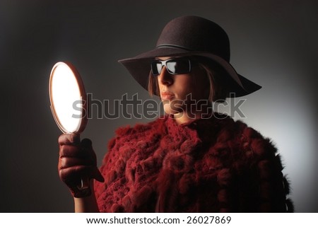 a woman glamorous looking with a mirror