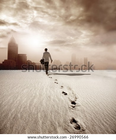 man walking in a desert towards a city