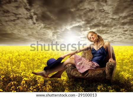 pretty girl sited on armchair in a field of yellow flowers