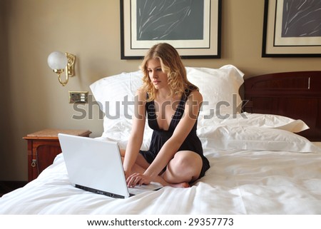 stock photo elegant woman using laptop in a luxury bedroom