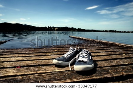 a pair of tennis shoes abandoned on a wooden wharf
