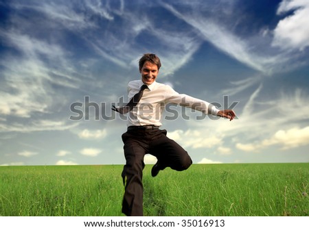 happy business man jumping in the grass