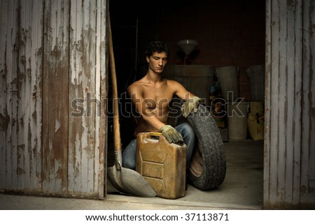 handsome worker with wheel and tank in the garage