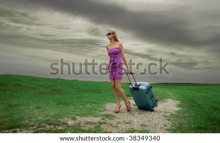 elegant woman with trolley lost in the countryside