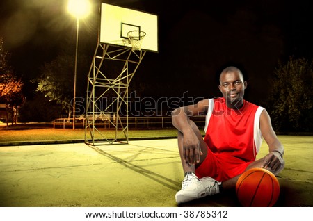 black basketball player seated in a field at night
