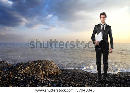 young businessman with laptop at the seaside