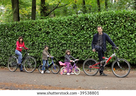 happy family riding bikes in a park