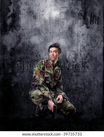 young guy in military uniform with gun
