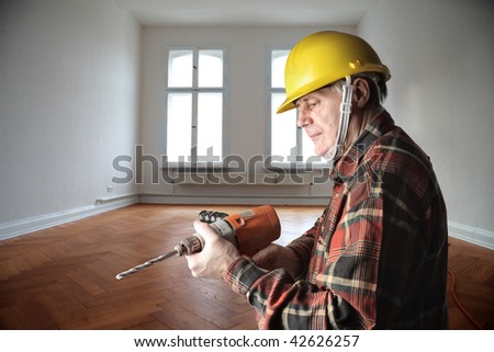 worker with drill in a house interior