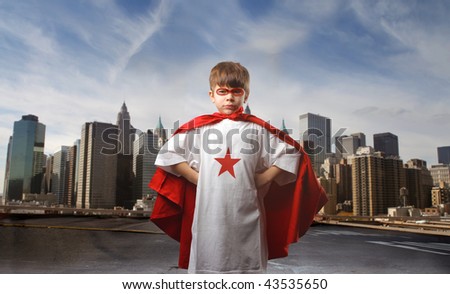 child in super hero costume and city on the background