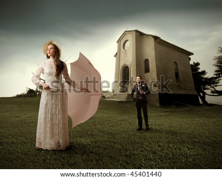 stock photo Woman in wedding dress with bridegroom and a church on the 