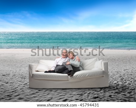 Portrait of a senior couple sitting in a sofa in the middle of a beach