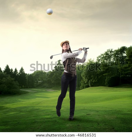 Portrait of a woman shooting a golf ball on a green meadow