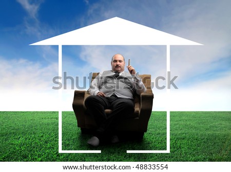 Overweight man sitting in an armchair on a green meadow surrounded by the form of a house