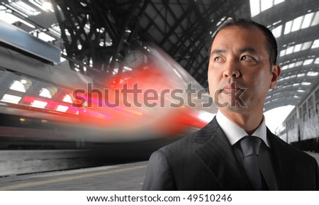 Japanese Businessman standing on the platform of a train station