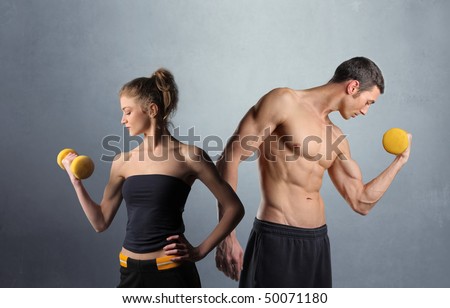 Young man and woman lifting weights