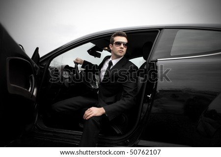 Fashionable businessman coming out of a car