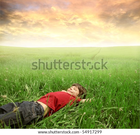 Smiling child lying on a green meadow