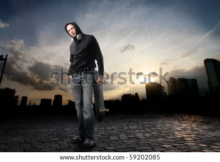 Young man in street-wear standing on a city street