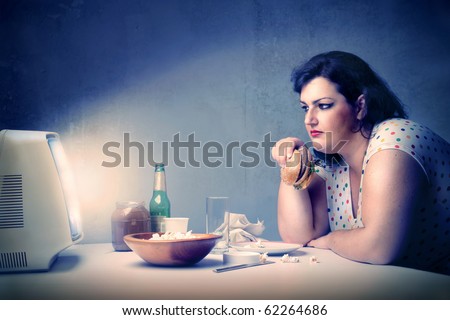 Fat woman dining in front of the television