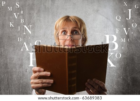 Amazed woman reading a book with letters flying away from it