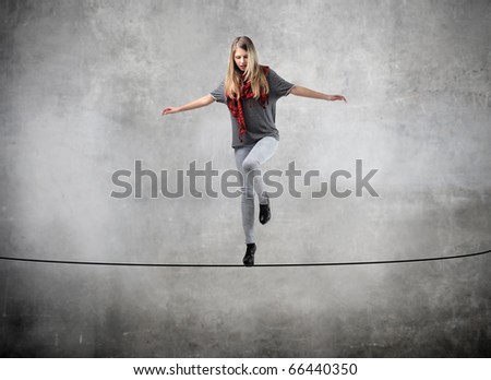 Beautiful woman standing on a rope over the void