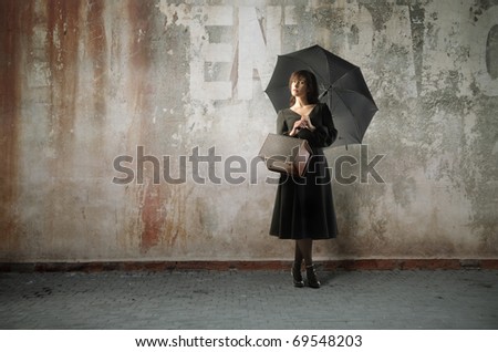Beautiful woman with umbrella standing on a city street