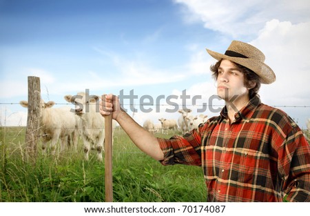 Young farmer with animals on the background