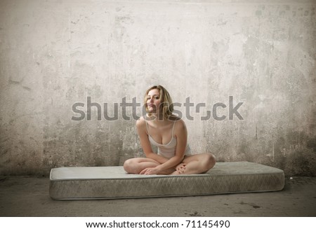 Beautiful woman in lingerie sitting on a mattress