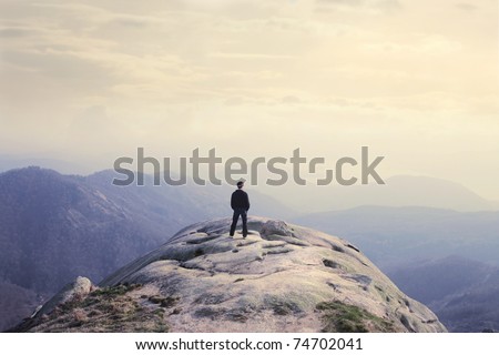 Man on a stone observing the landscape