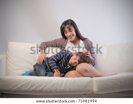 Mother cuddling her child on a sofa