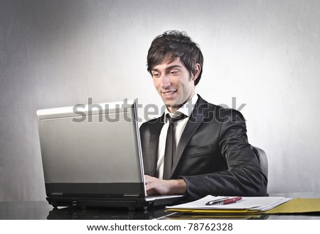 Smiling young businessman using a laptop