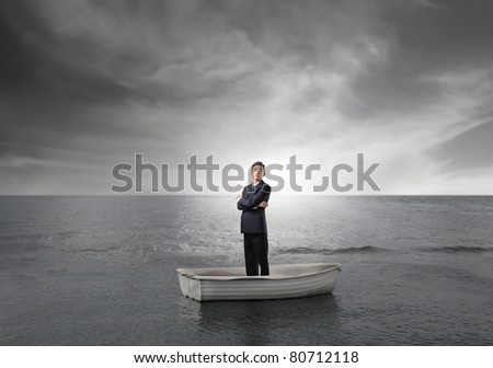 Businessman on a boat in the middle of the sea