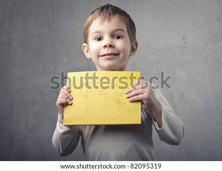 Smiling child holding a paper sheet with the Earth on it