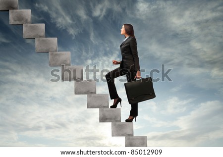 Businesswoman stepping up a stairway with sky in the background