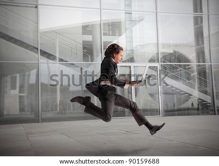 Businessman running fast with office building in the background