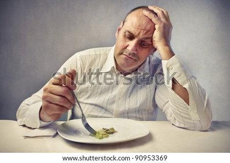 Sad fat man eating vegetables