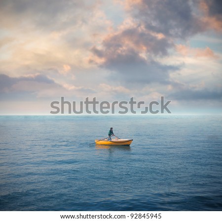 Lonely man on a boat in the middle of the sea