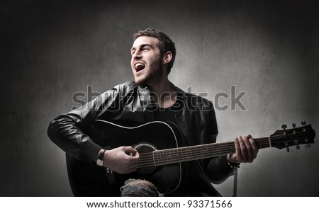 Young man playing the guitar and singing Young man playing the guitar and singing