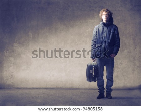 Young man holding a trolley case